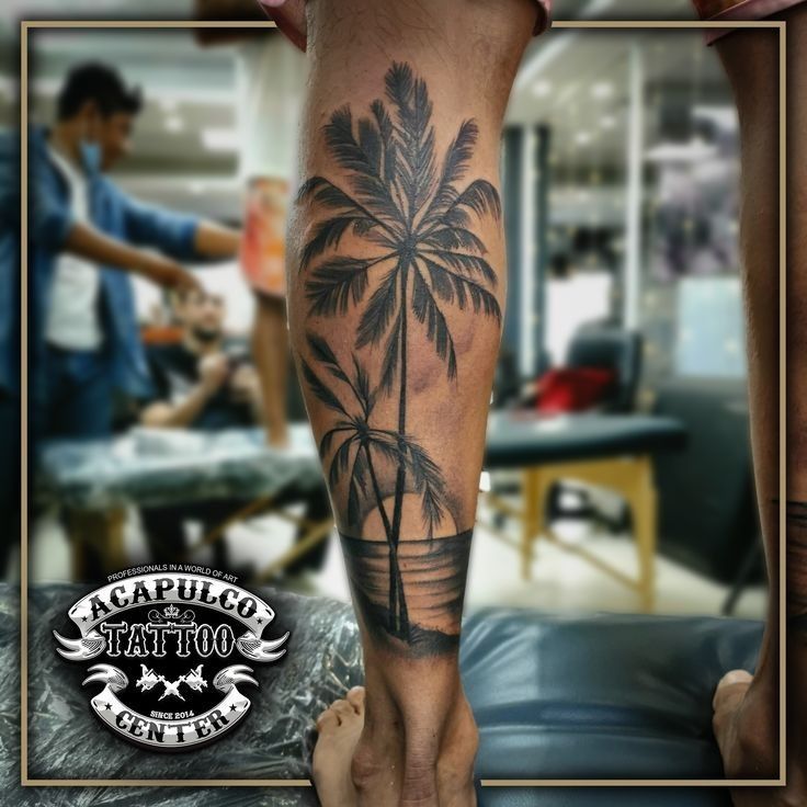 a man's leg with a palm tree tattoo on it and his foot in the foreground