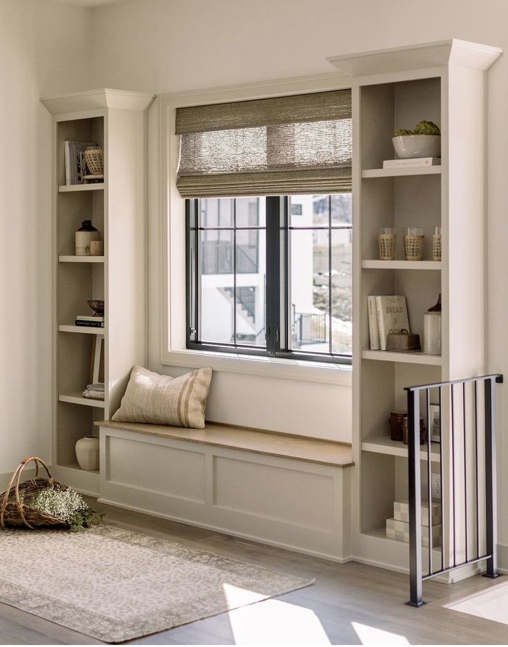 a window seat in the corner of a room with bookshelves and shelves on either side