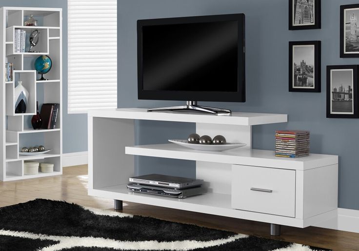 a white entertainment center with a flat screen tv mounted on it's sideboard