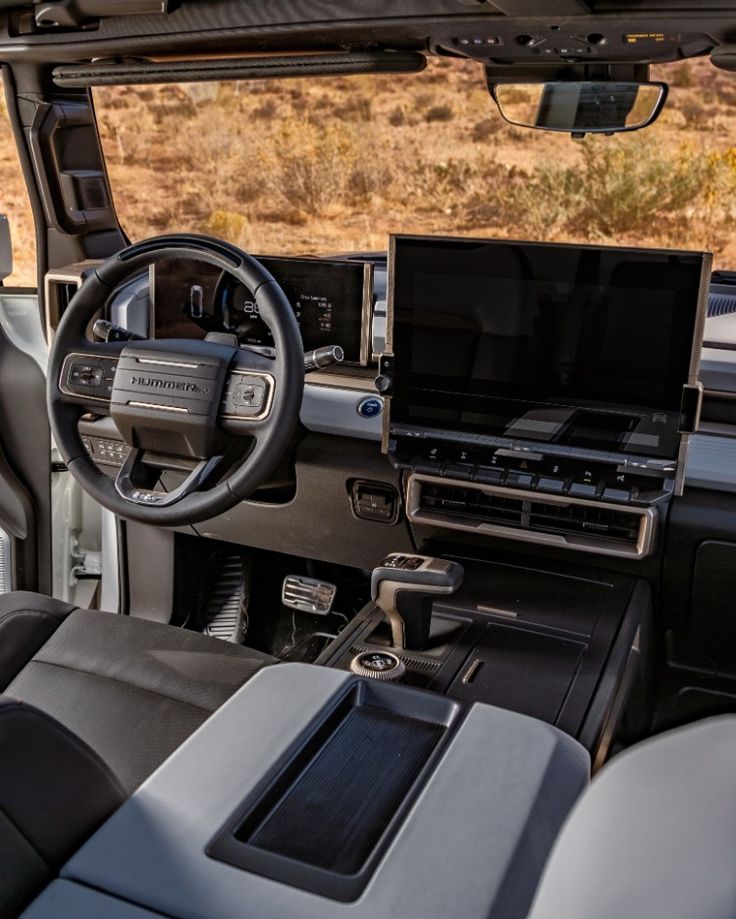 the interior of a vehicle with an entertainment center and laptop on the dash board in front of it