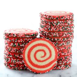 several red and white cookies stacked on top of each other with sprinkles