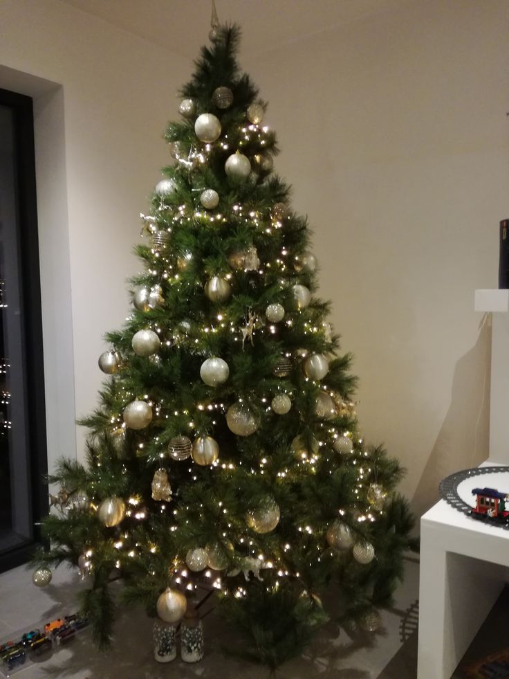 a small christmas tree is decorated with silver and white ornaments