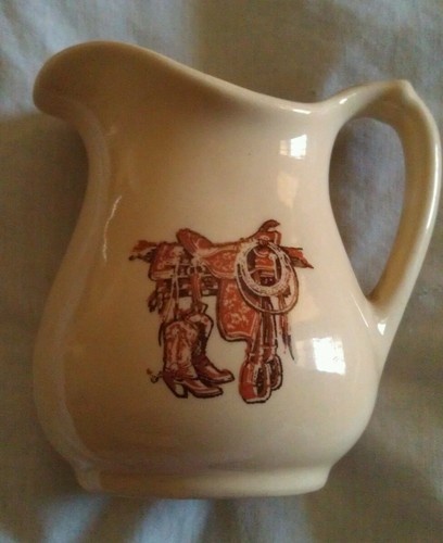 a white pitcher with an image of a cowgirl on it