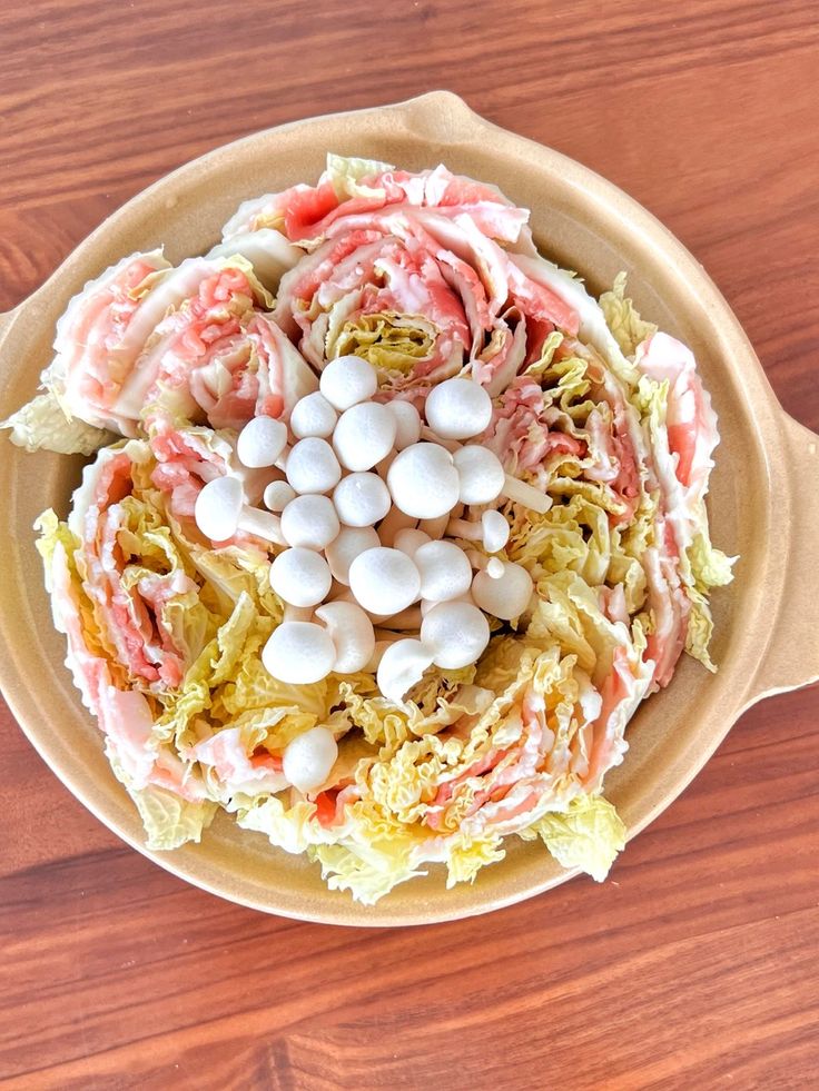 a bowl filled with lots of food on top of a wooden table