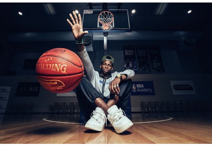 a man sitting on the floor with a basketball in his hand