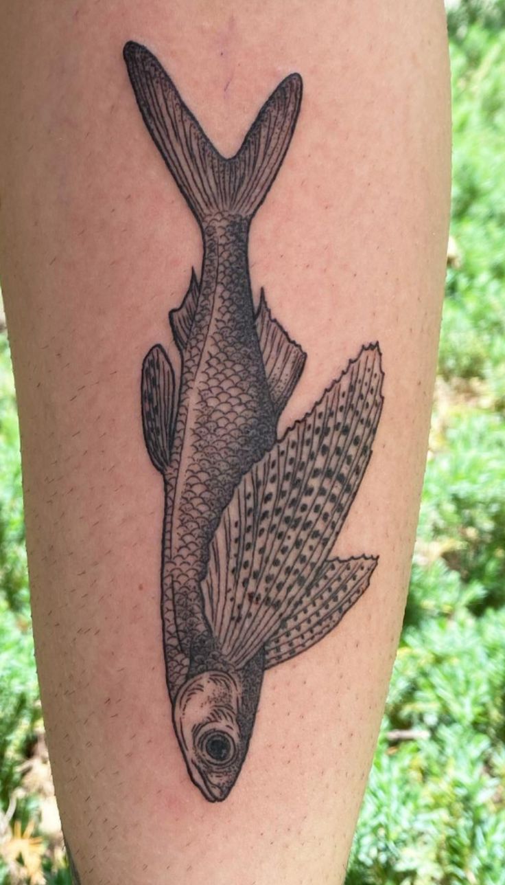 a black and white fish tattoo on the leg