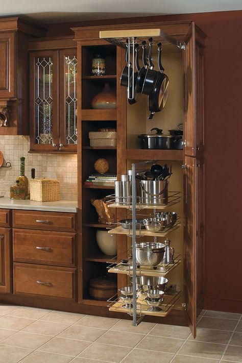 an open cabinet with pots and pans on it in the middle of a kitchen