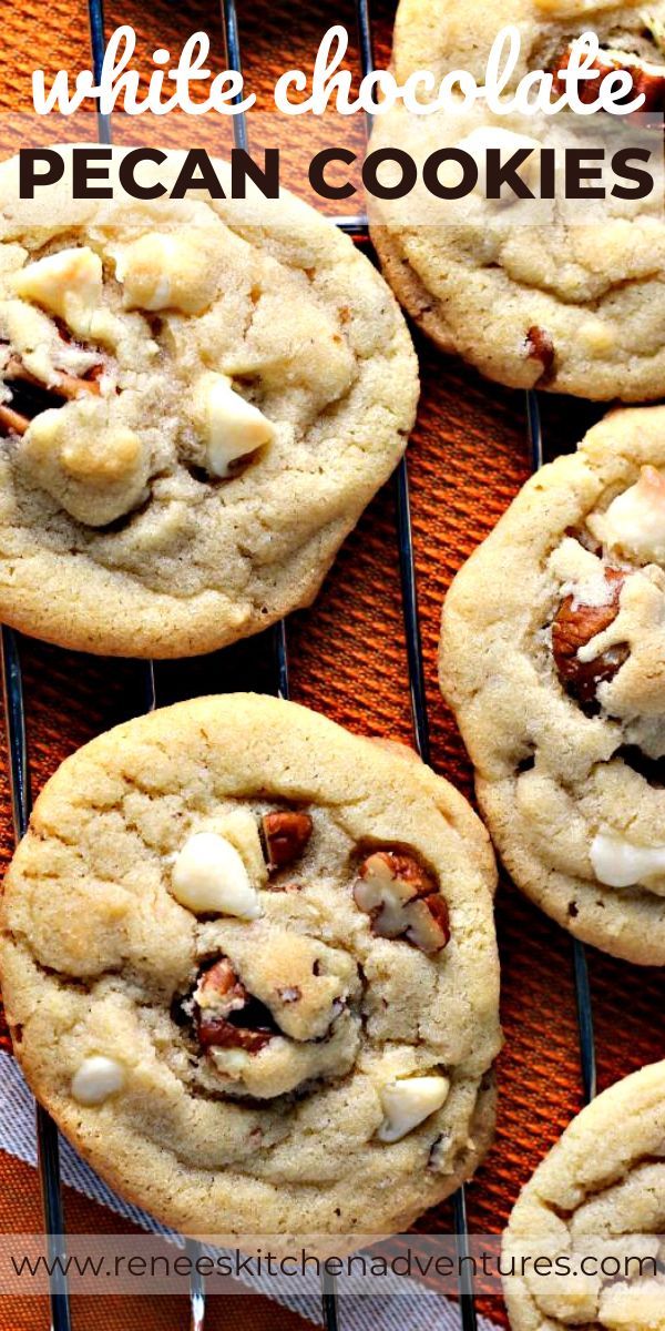 several cookies are cooling on a rack with white chocolate chips and pecans in the middle