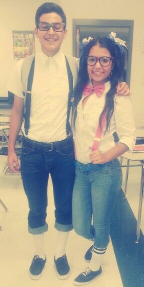 a man standing next to a woman wearing suspenders and bow ties in an office