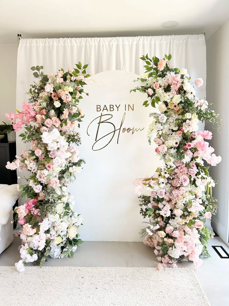 a baby in bloom backdrop with pink and white flowers