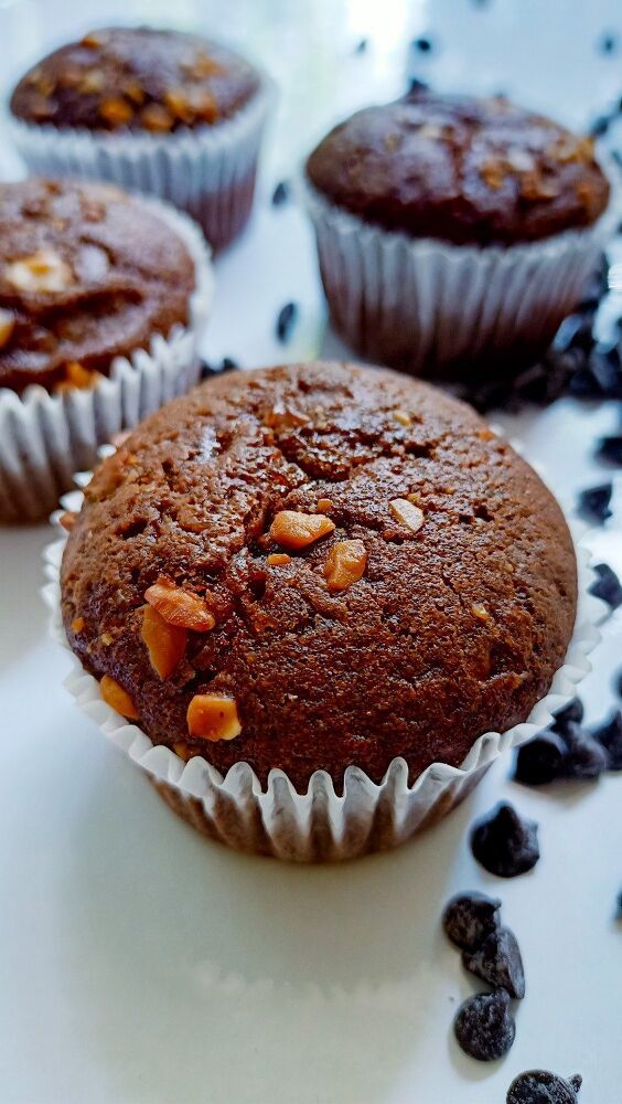 several chocolate muffins are on a gold plate