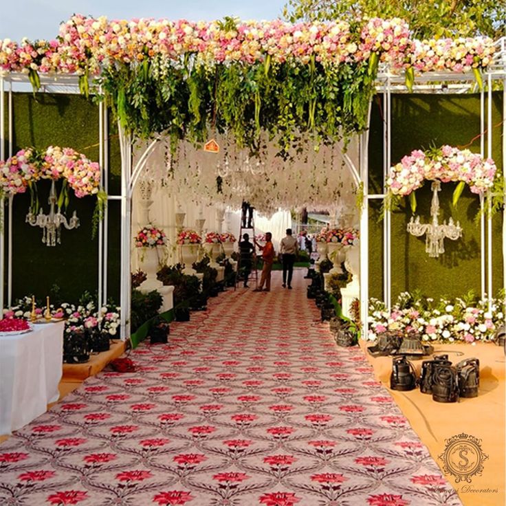 an outdoor ceremony with flowers and chandeliers