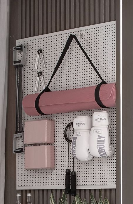 there is a wall mounted rack with boxing gloves and other sports equipment on the pegboard