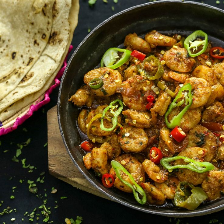 a skillet filled with chicken and vegetables next to tortilla chips on a table