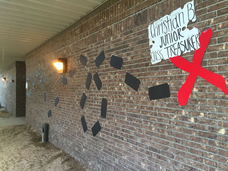 a brick wall that has been decorated with black and red pieces of paper taped to it