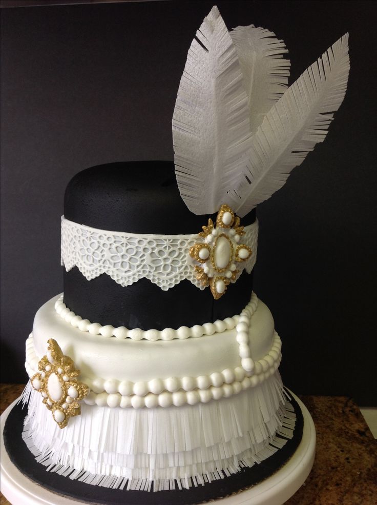 a three tiered cake with white and black decorations