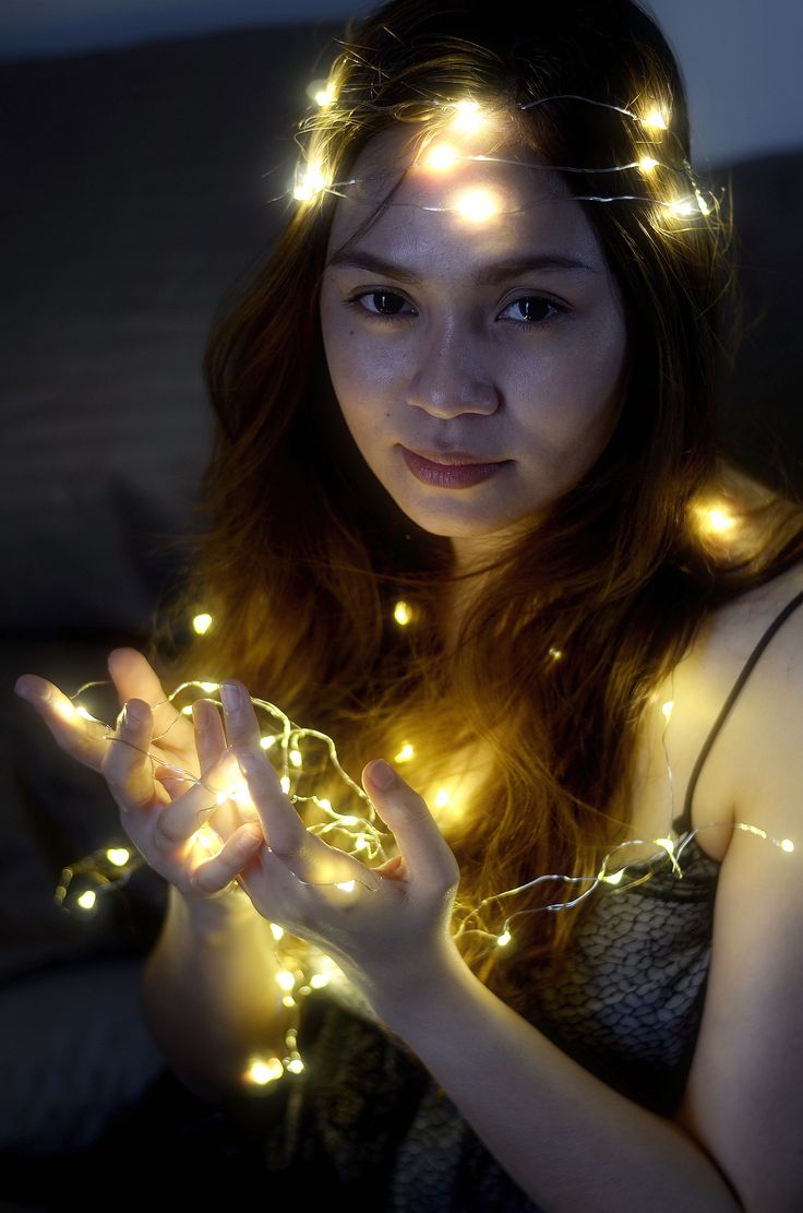 a woman is holding some lights in her hands