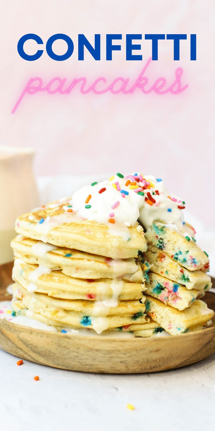 a stack of pancakes with white frosting and sprinkles