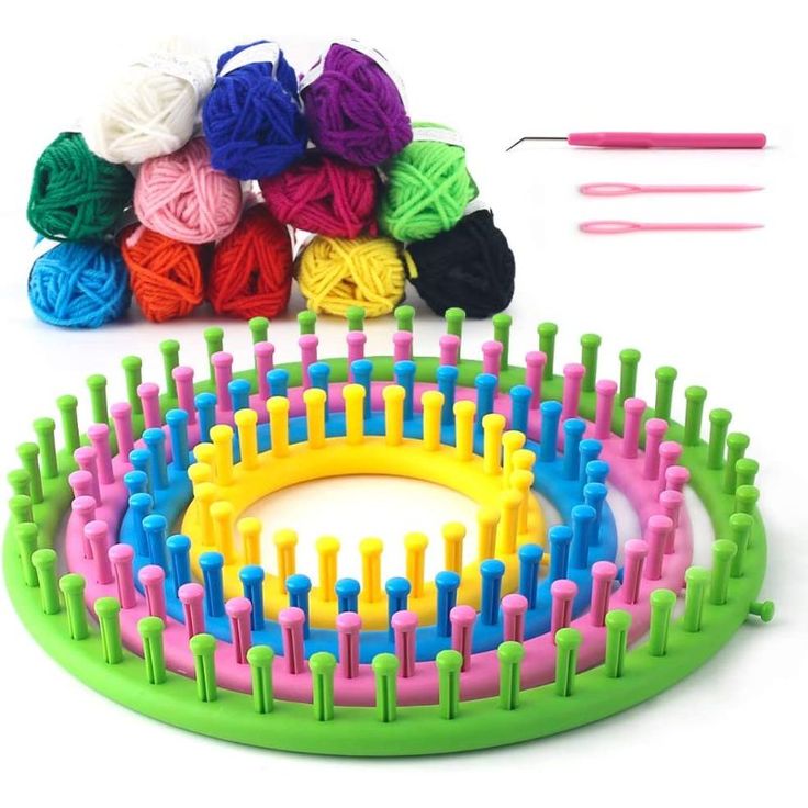 colorful yarn and crochet hooks laid out on a white surface with balls of yarn in the background