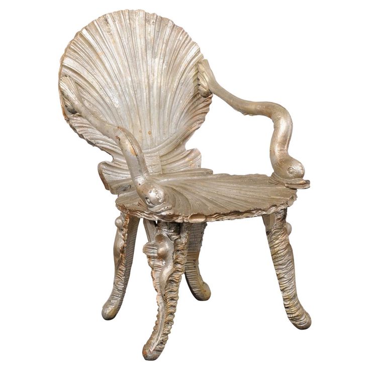 an antique shell chair is shown against a white background, with the back turned to look like it's been carved