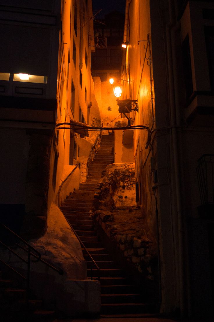 an alleyway with stairs lit up at night