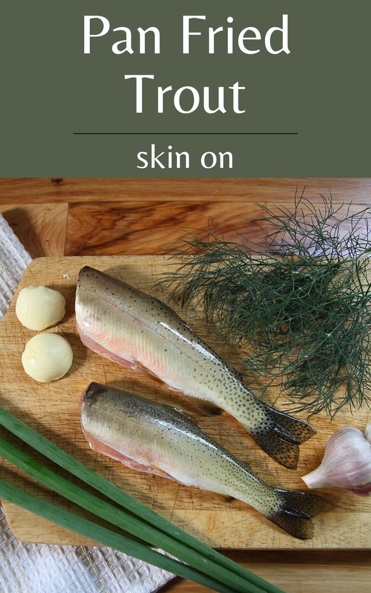 some fish and garlic on a cutting board with the title pan fried trout skin on