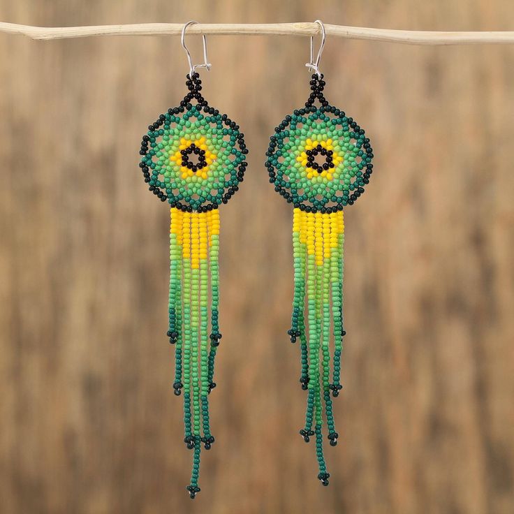 Elaborated with verdant hues of green and yellow a majestic pair of waterfall earrings is handcrafted with petite glass beads. Learning from her parents and grandparents Mexican artisan Adriana Trejo designs this inspiring accessory. Each earring dangles from a hook of sterling silver. Traditional Green Teardrop Beaded Earrings, Green Beaded Teardrop Jewelry, Bohemian Green Chandelier Earrings With Colorful Beads, Green Bohemian Chandelier Earrings With Colorful Beads, Green Chandelier Earrings With Dangling Beads As A Gift, Green Jewelry With Dangling Round Beads, Artisan Green Czech Glass Earrings, Green Beaded Dangle Chandelier Earrings, Green Teardrop Beaded Earrings With Dangling Beads