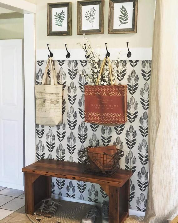 a wooden bench sitting in front of a wall with pictures on it