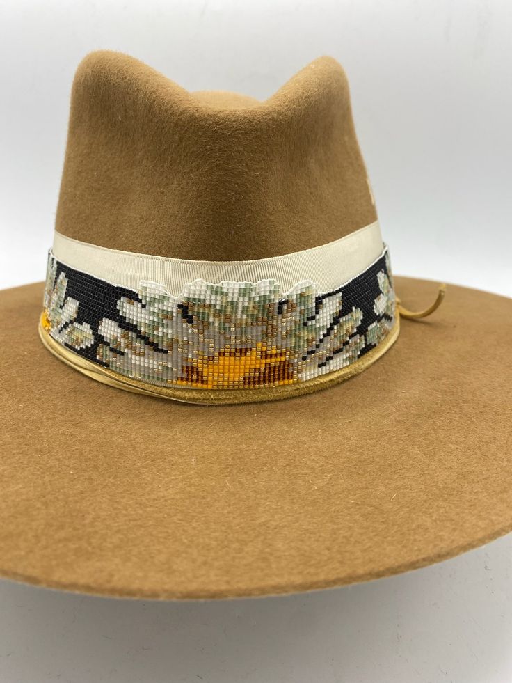 Western 50x in Camel Teardrop crown and 3 inch brim Daisy Flower hand loomed beaded band layered on Vintage Ribbon Elk leather accent band Feather Bundle with magnet attachment Hand stitched Mountain detail This felt hat is made to order, please allow 6-8 weeks for delivery. Mountain Hat, Beaded Hat Bands, Mountain Style, Beaded Hat, Native Beadwork, Hat Ideas, Vintage Ribbon, Handmade Hat, Hat Band