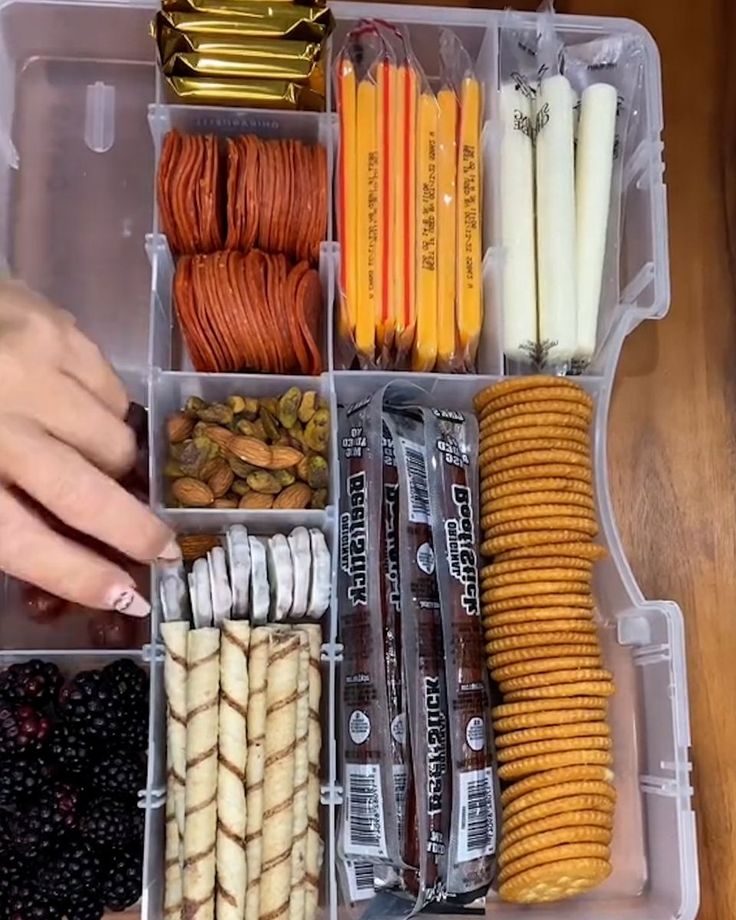 a plastic container filled with lots of different types of snacks and candy bar wrappers