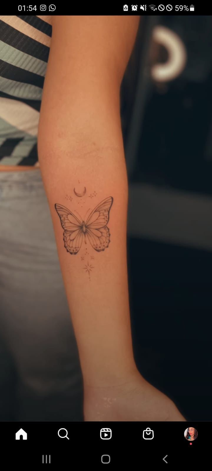 a woman's arm with a butterfly tattoo on the left side of her arm