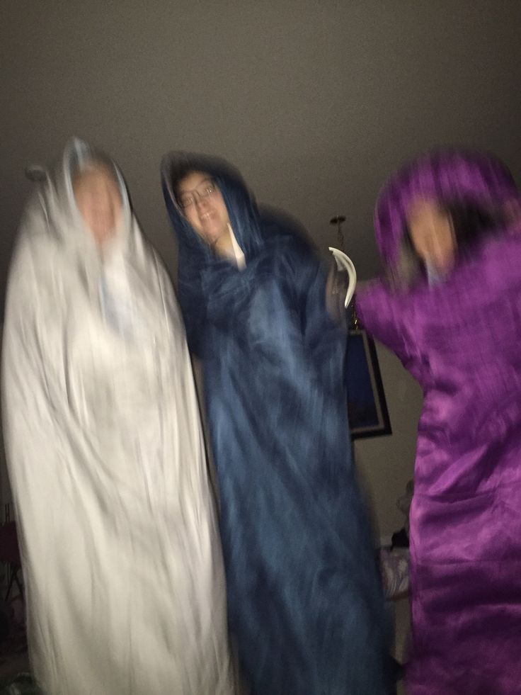 three people dressed in raincoats standing next to each other