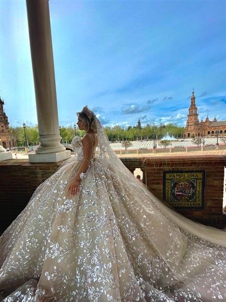 a woman in a wedding dress standing on a balcony