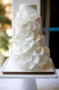 a three tiered cake with white flowers on it