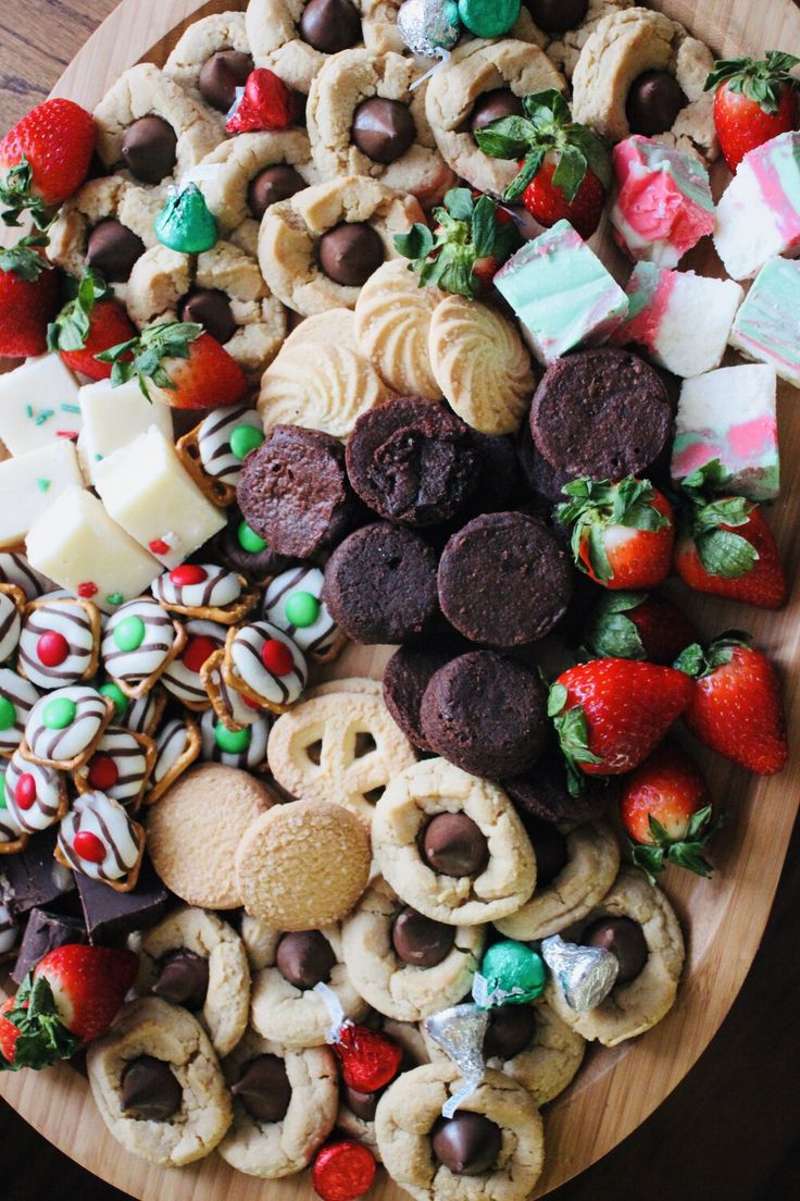 a wooden platter filled with cookies, pretzels and candy