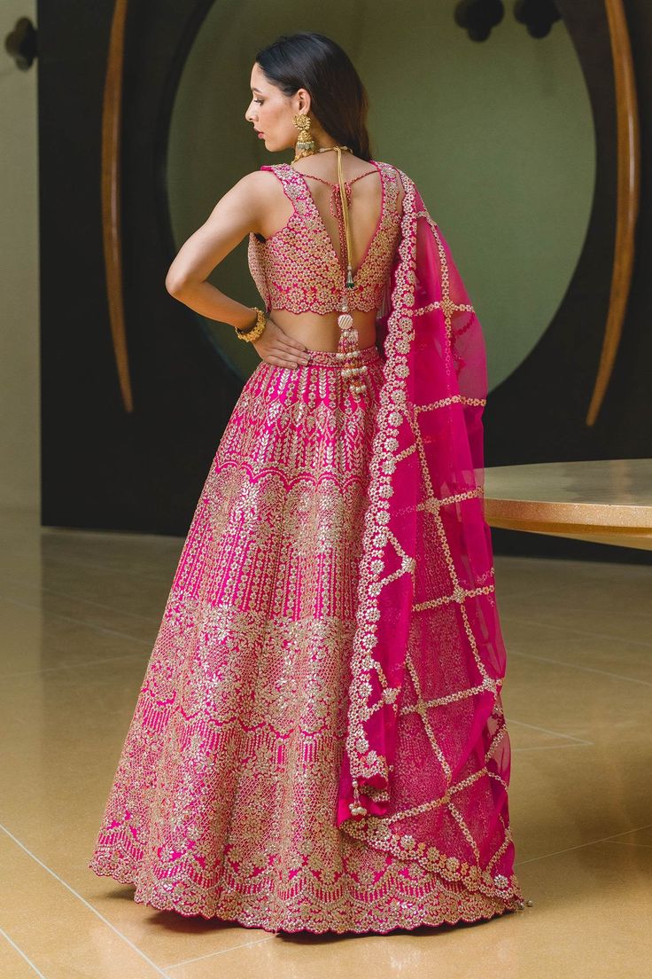 Fuchsia pink lehenga with attached cancan, highlighted with intricate gota embroidery, sequin embellishments and drawstring with tassels. Comes with V-neckline padded blouse and dupatta.
Component: 3
Embroidered
Neckline: V-Neck
Sleeve Length: Sleeveless
Fabric: Lehenga and Blouse: Taffeta; Dupatta: Tulle
Color: Pink
Gota, resham, sequin, beads and crystal embroidery
Embroidered blouse with cutwork hemline
Tie-up at the back with tassels
Embroidered dupatta with scallop edge and tassels - Aza Fa Pink Art Silk Set For Wedding, Pink Art Silk Wedding Set, Pink Art Silk Choli For Wedding, Pink Art Silk Gown With Traditional Drape, Traditional Drape Pink Art Silk Gown, Wedding Pink Art Silk Choli, Pink Art Silk Gown With Pallu, Pink Art Silk Gown For Reception, Pink Art Silk Gown With Cutdana Details