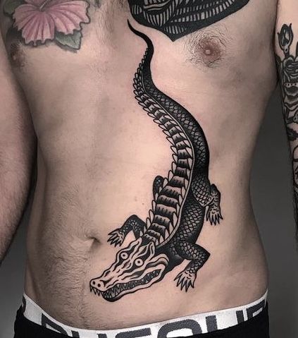 a man with a tattoo on his stomach has a lizard on his chest and is looking at the camera