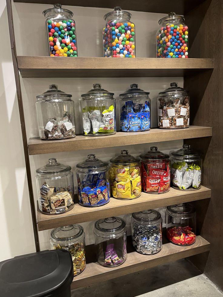 the shelves are filled with many different types of candies and candy in glass jars