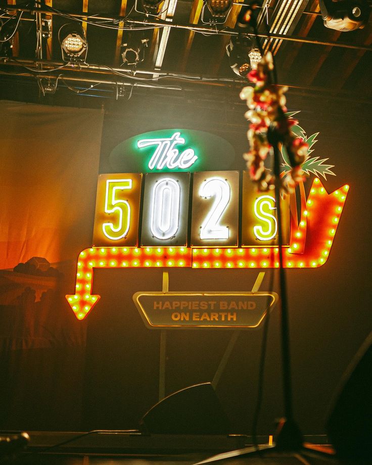 a neon sign that reads the 502 s on it's side in front of a stage