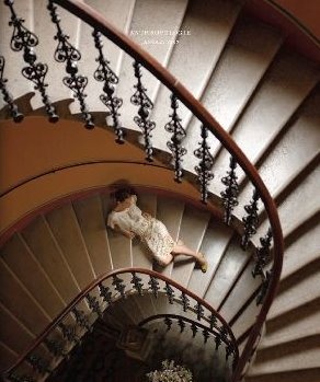 a spiral staircase with a teddy bear sitting on the railing and in front of it