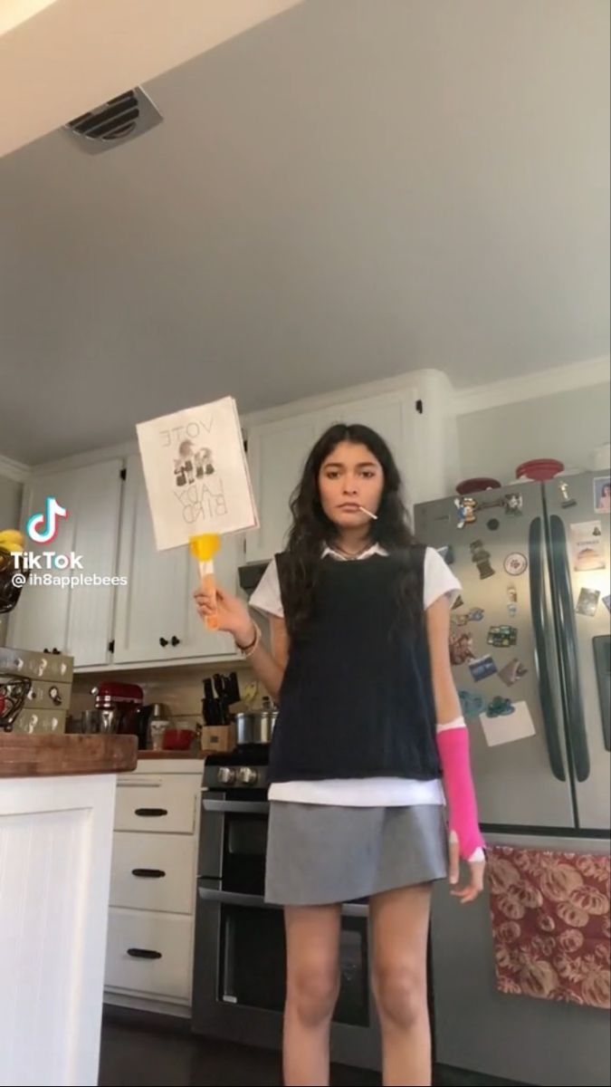 a woman standing in a kitchen holding an ice cream cone