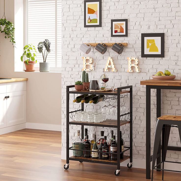 a bar cart with wine glasses and bottles on it in front of a brick wall