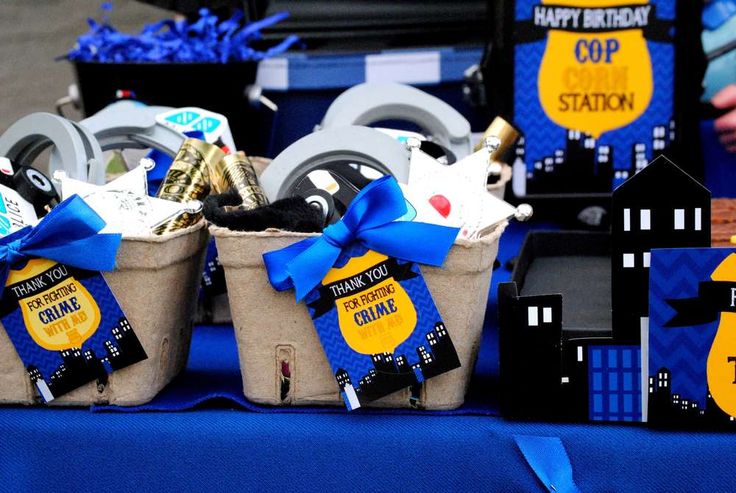 two baskets filled with items sitting on top of a blue table covered in ribbon and decorations