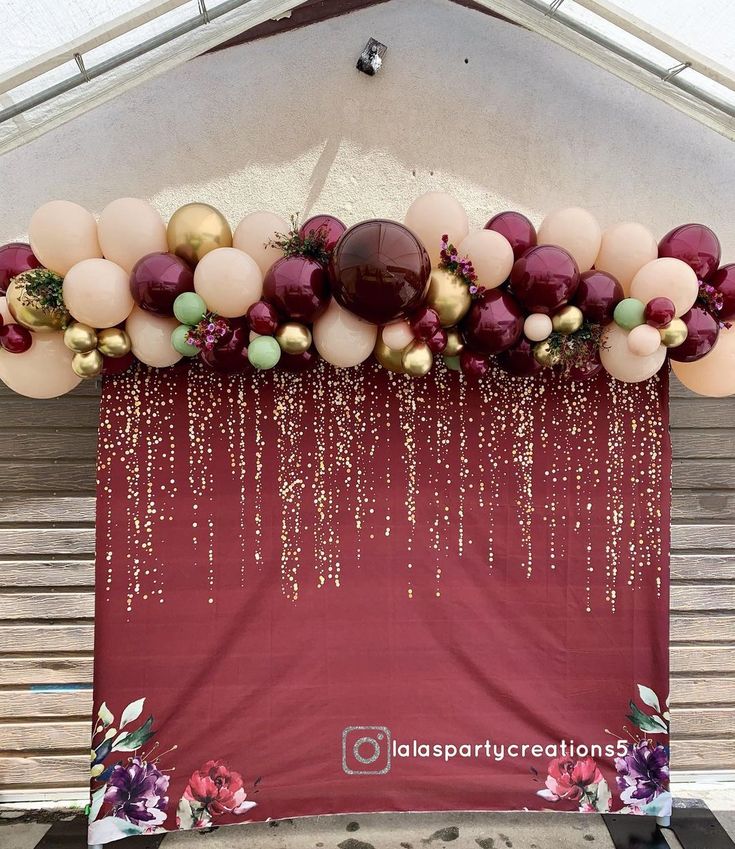 an arch with balloons and confetti hanging from it