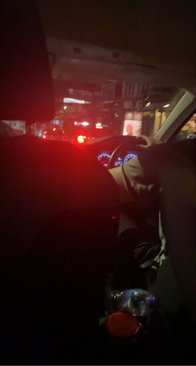 the back seat of a car is lit up with red lights and emergency vehicles in the background