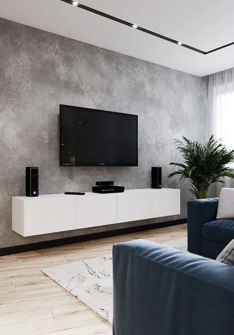 a living room with couches and a flat screen tv mounted to the side of a wall