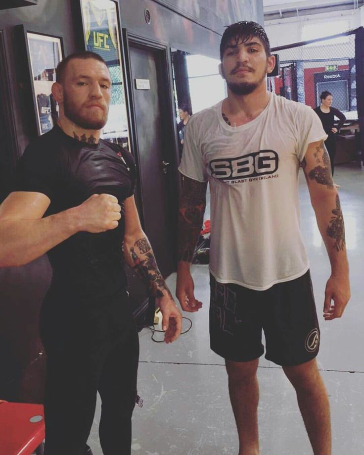 two men standing next to each other in front of a mirror with tattoos on their arms