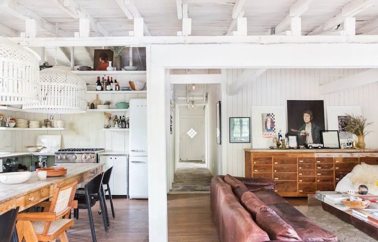 a living room filled with furniture next to a kitchen