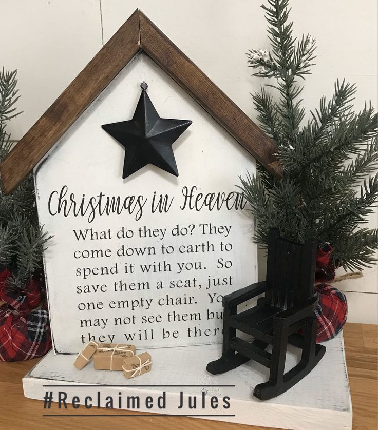 a christmas in heaven sign with a rocking chair next to it and a small tree