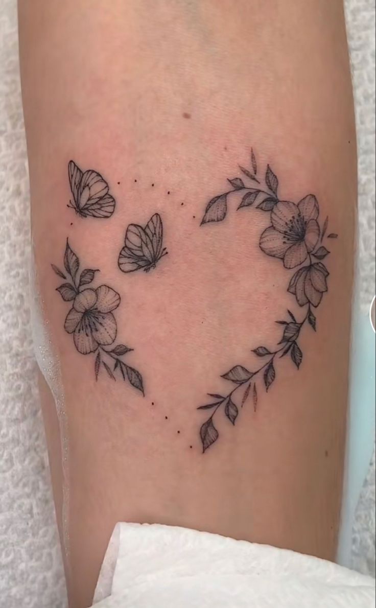 a heart shaped tattoo with flowers on it